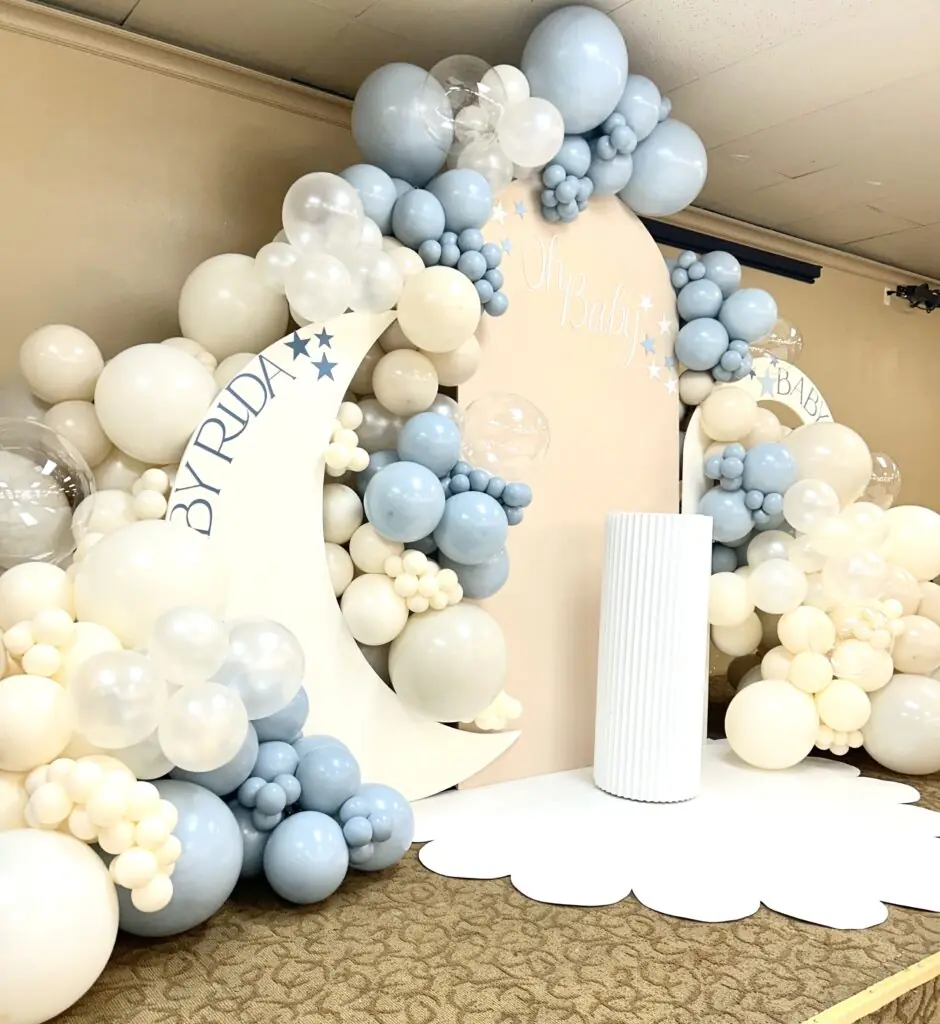 stunning backdrop setup for instagram photos for a 1st birthday party in snohomish county & king county. Featuring a custom moon backdrop / moon prop, custom cake stand, backdrop arch, scalloped floor mat, rainbow arch, custom vinyl signage, and balloon garlands from bradbury events.