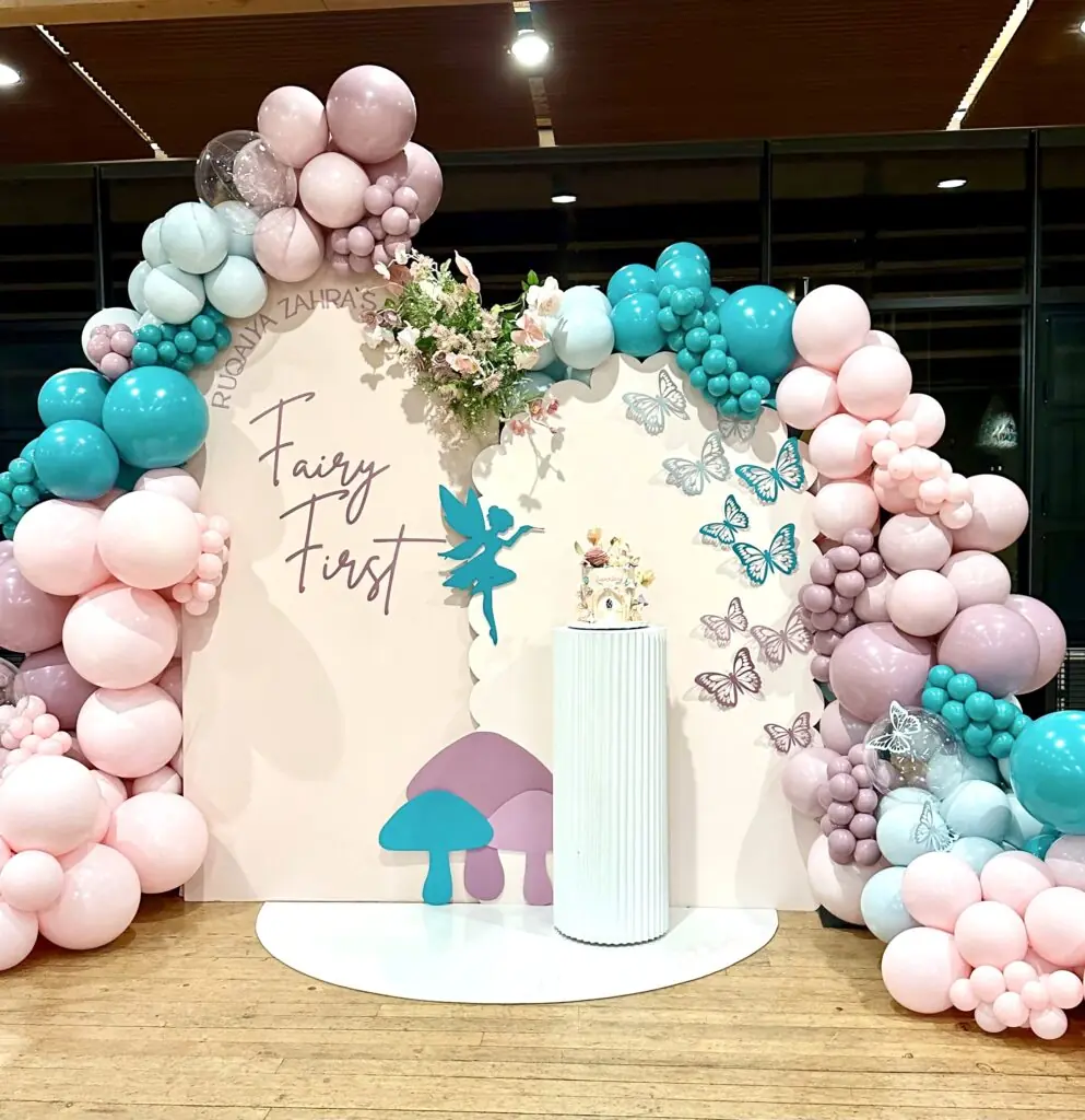 Stunning backdrop setup for instagram photos for a kids 1st birthday party in snohomish county & king county. Featuring a custom fairy prop / butterfly props, custom cake stand, backdrop arch, arched floor mat, custom vinyl signage, and balloon garlands from bradbury events.