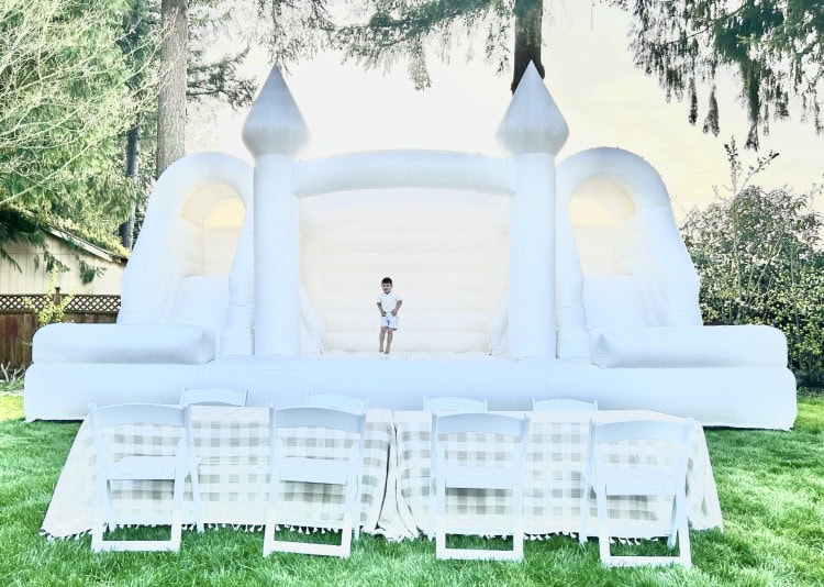 kids party in the backyard with luxury bounce house rentals, featuring a huge white bounce house caste combo with slides and kids seating in snohomish county & king county.