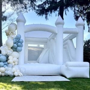 Luxury bounce house rentals with white bounce house combo slide and stunning pastel balloon garland in Everett for a kids birthday party.