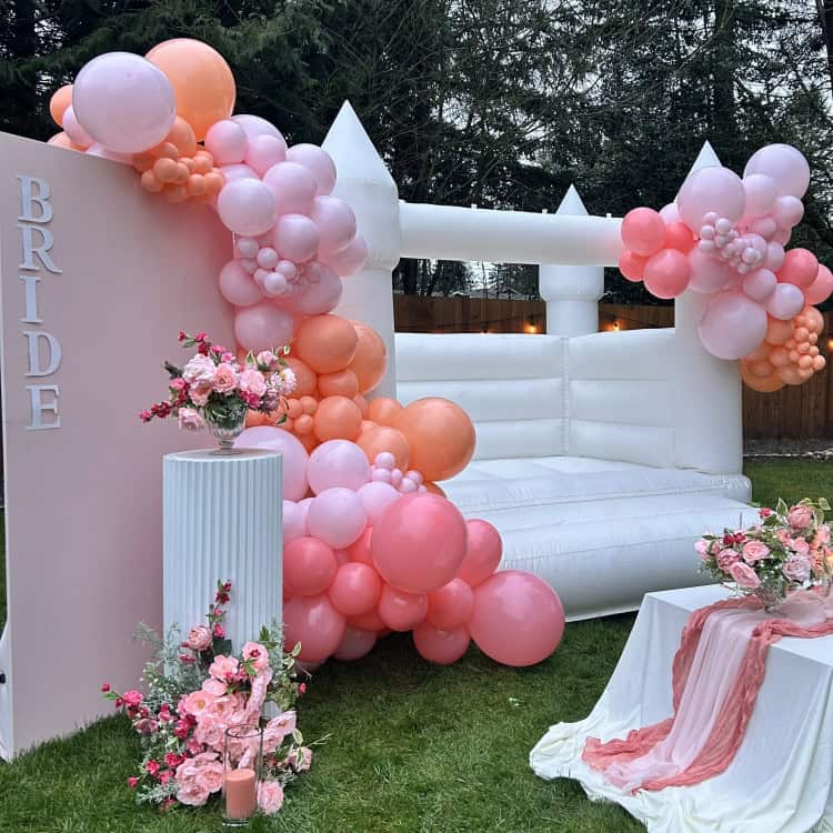 Luxury bounce house rental - bounce house rental in arlington with white bounce house castle and balloon garland for bridal shower in arlington