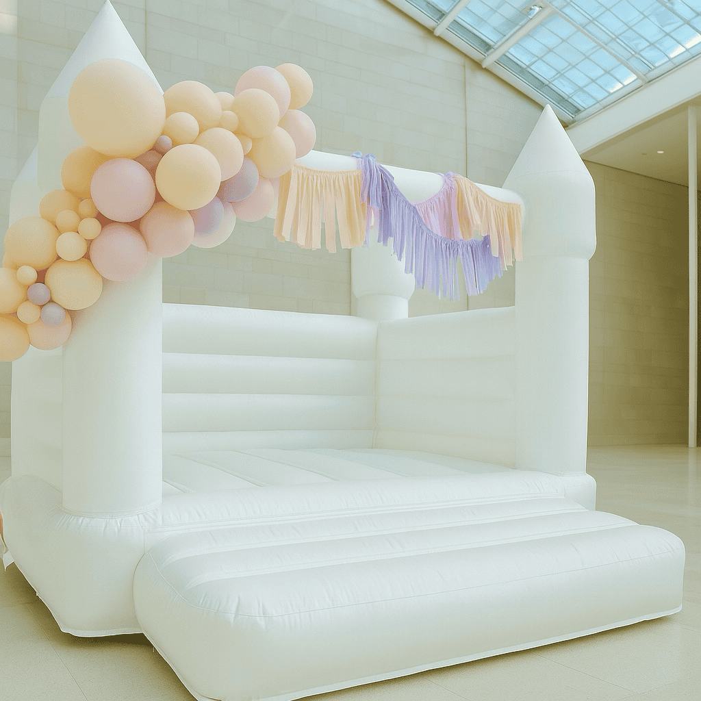 Petite Party Package: white bounce house styled with soft balloons and fringe detail; minimal airy indoor setting.