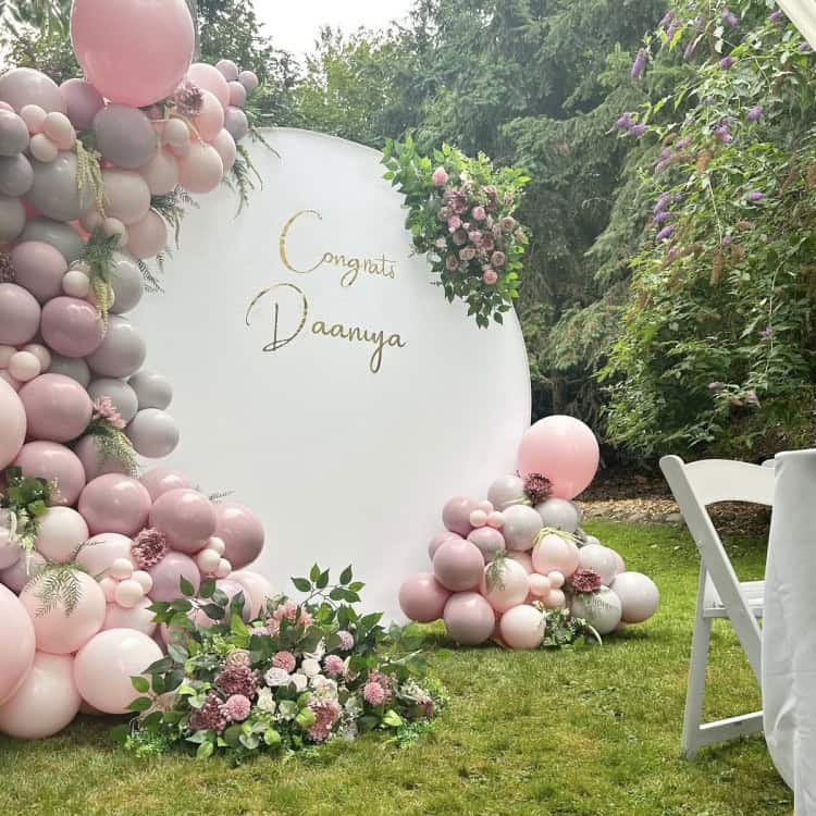 Photo: balloon garlands styled over a modern event backdrop wall for photos
