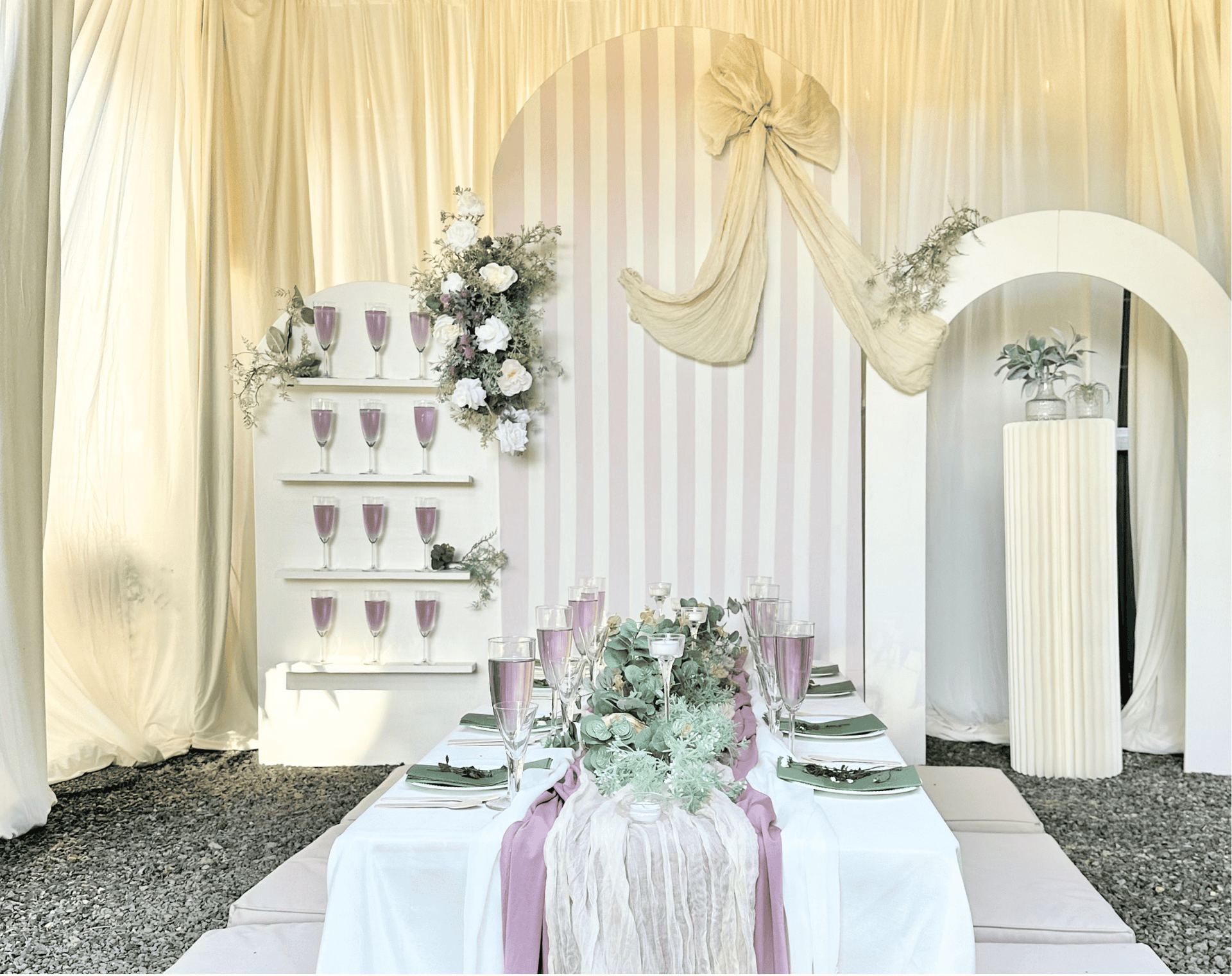Photo: modern arch event backdrop with pastel balloon garlands and a cake pedestal