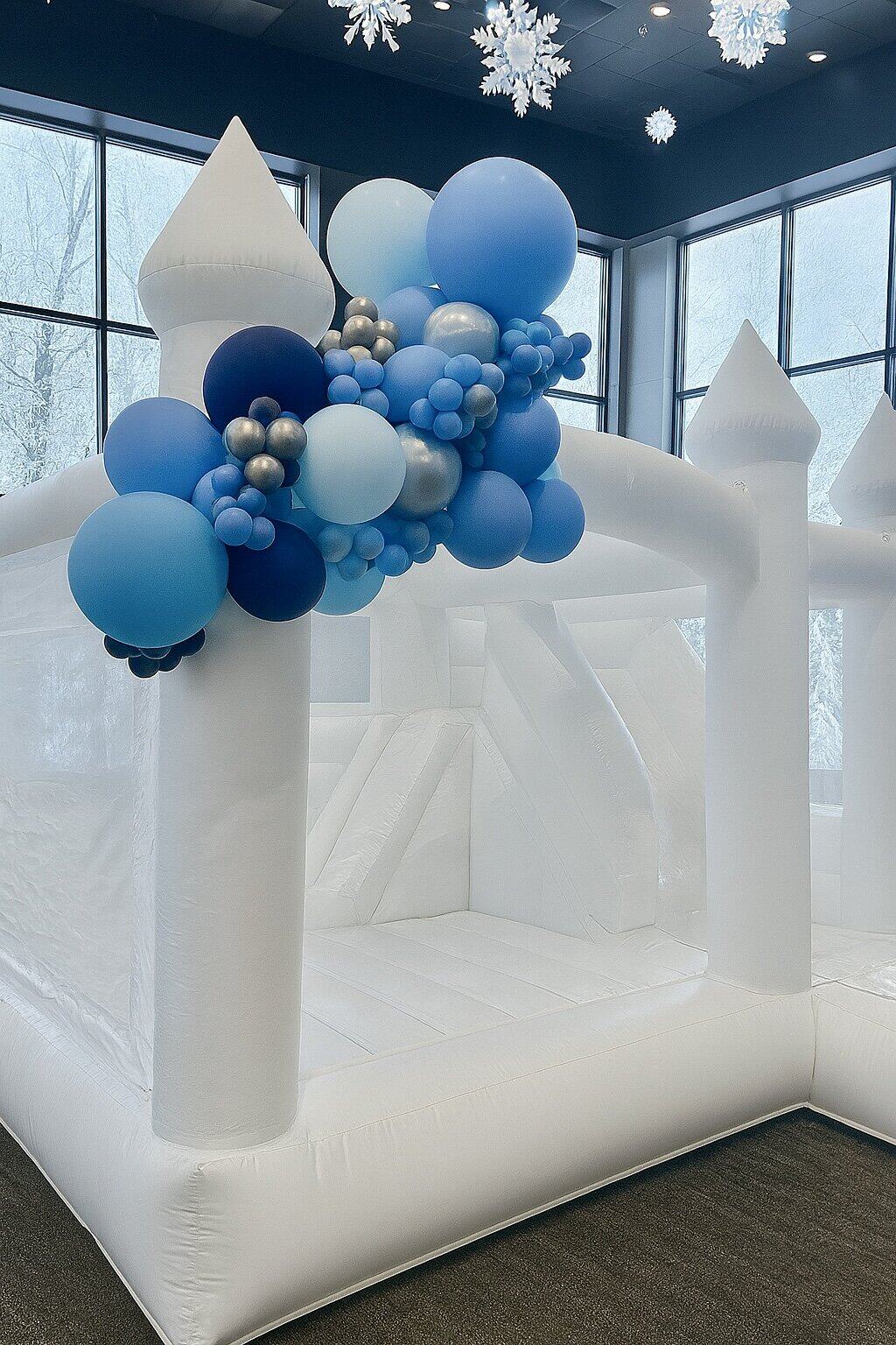 Photo: winter wonderland balloon garlands in icy blues, whites, and metallics styled around a modern backdrop.