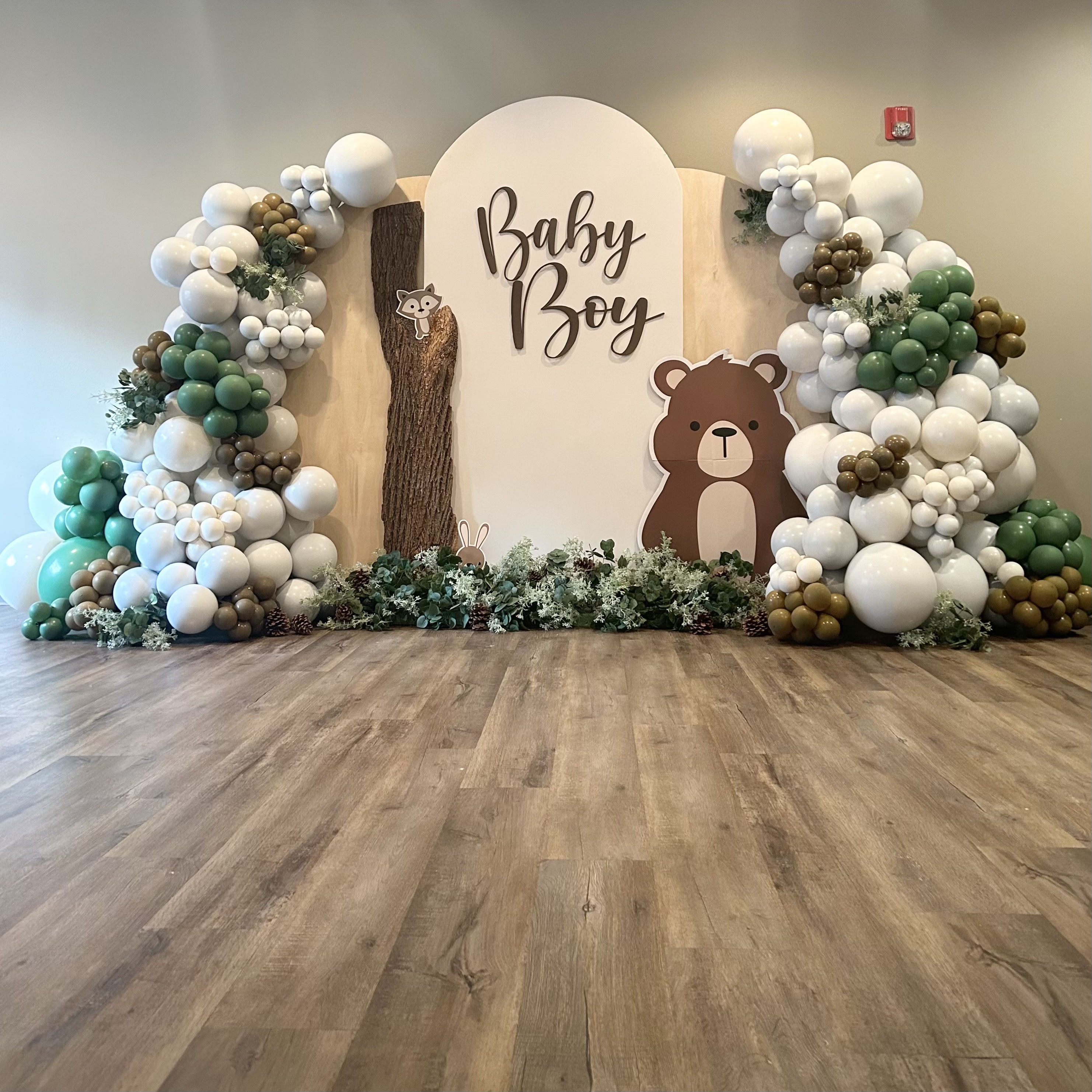 White, emerald, and gold balloon garland and woodland themed backdrop for a baby shower at Bistro 76 in Edmonds, WA