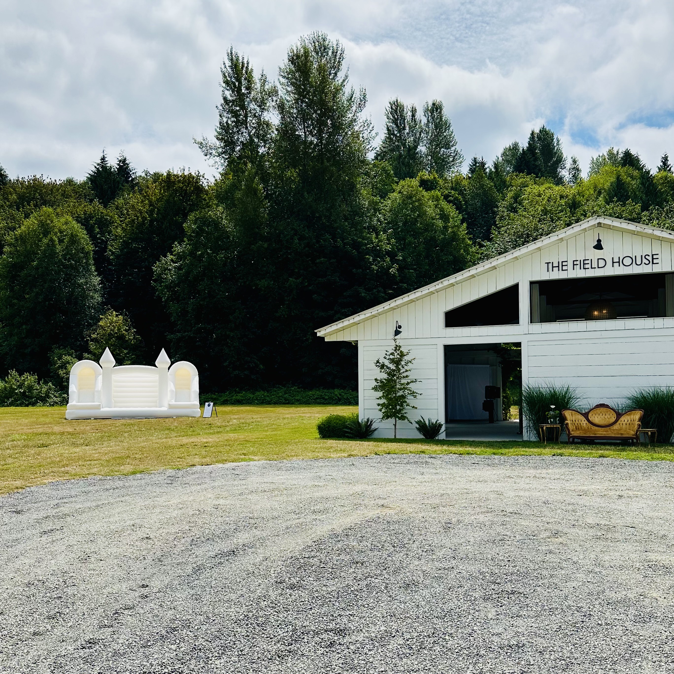 Olympus white bounce house with white balloon garland for a wedding at The Bannan House Farm in Lake Stevens, WA