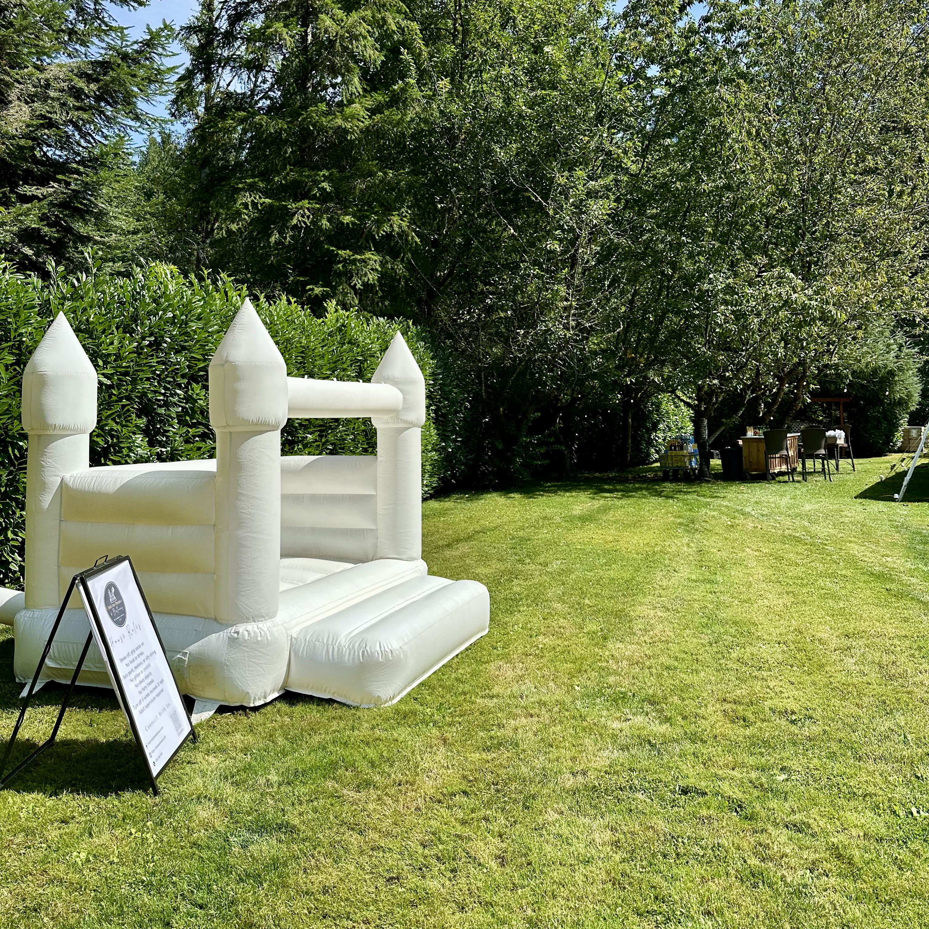 Thaya white bounce house with white balloon garland for a wedding at River Valley Oasis in Lake Stevens, WA