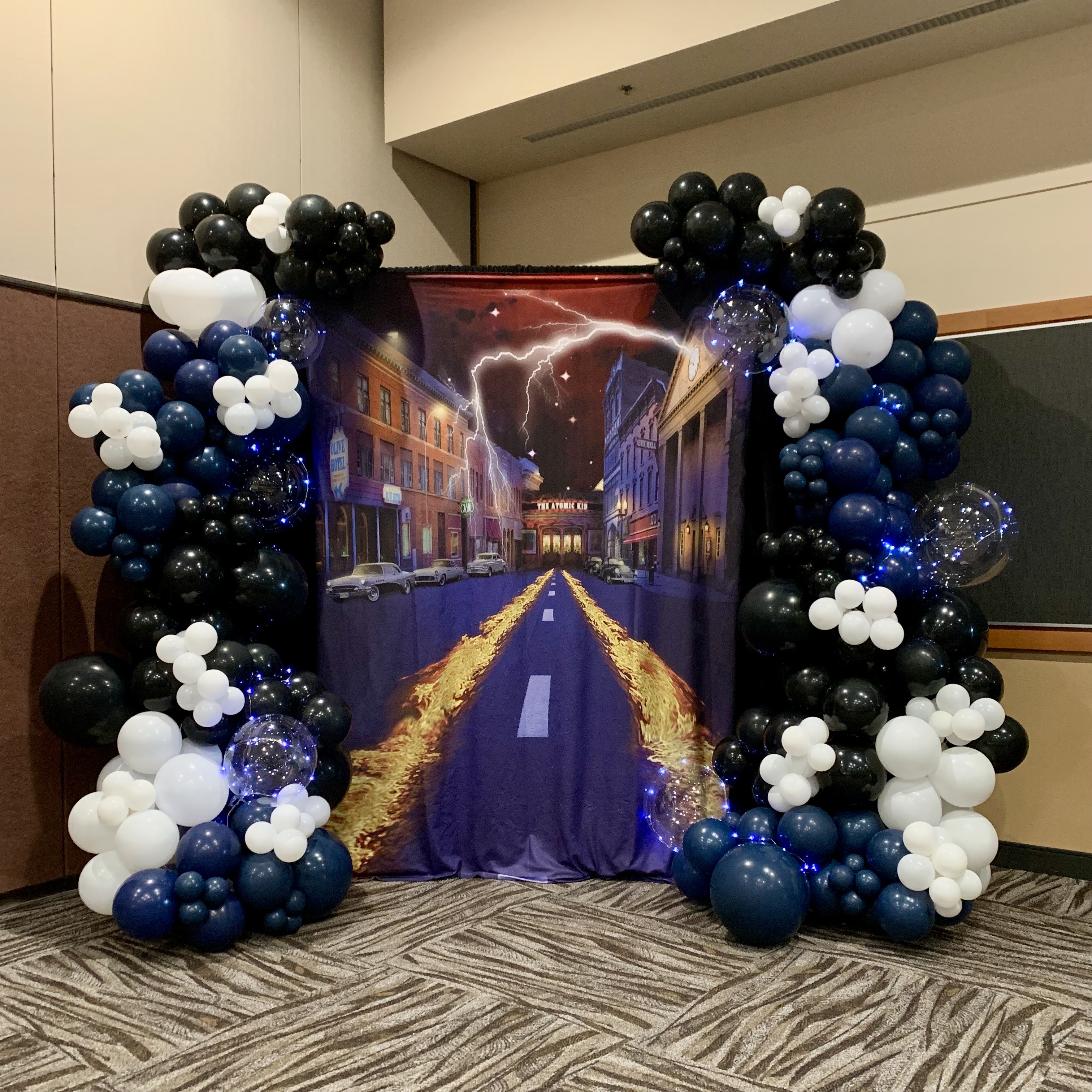 Black, white, and slate blue balloon garland and back to the future backdrop for a birthday at Lynnwood Event Center in Lynnwood, WA