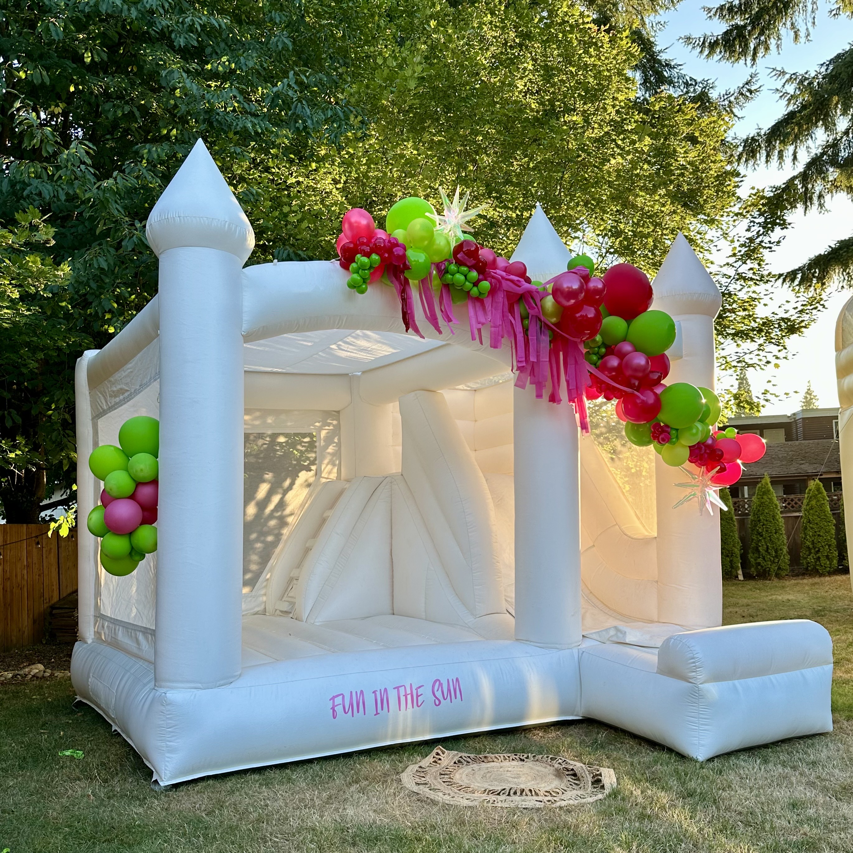 Ranier white bounce house with white, emerald, and dusty rose balloon garland for a Backyard Party in Marysville, WA