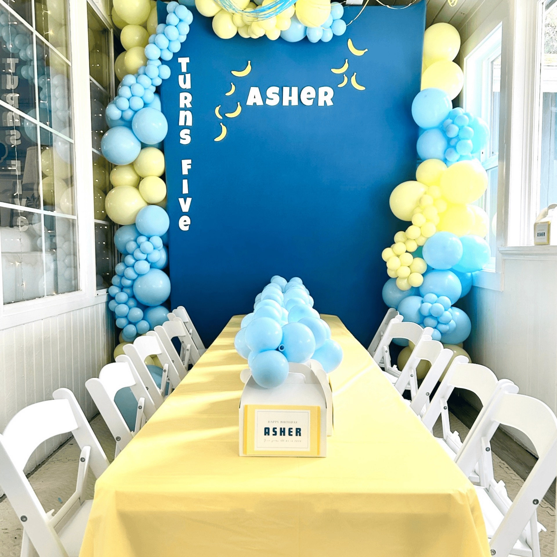 Luxury powder blue, yellow, and white organic balloon garland with banana themed accents for a fifth birthday backdrop in Monroe, WA