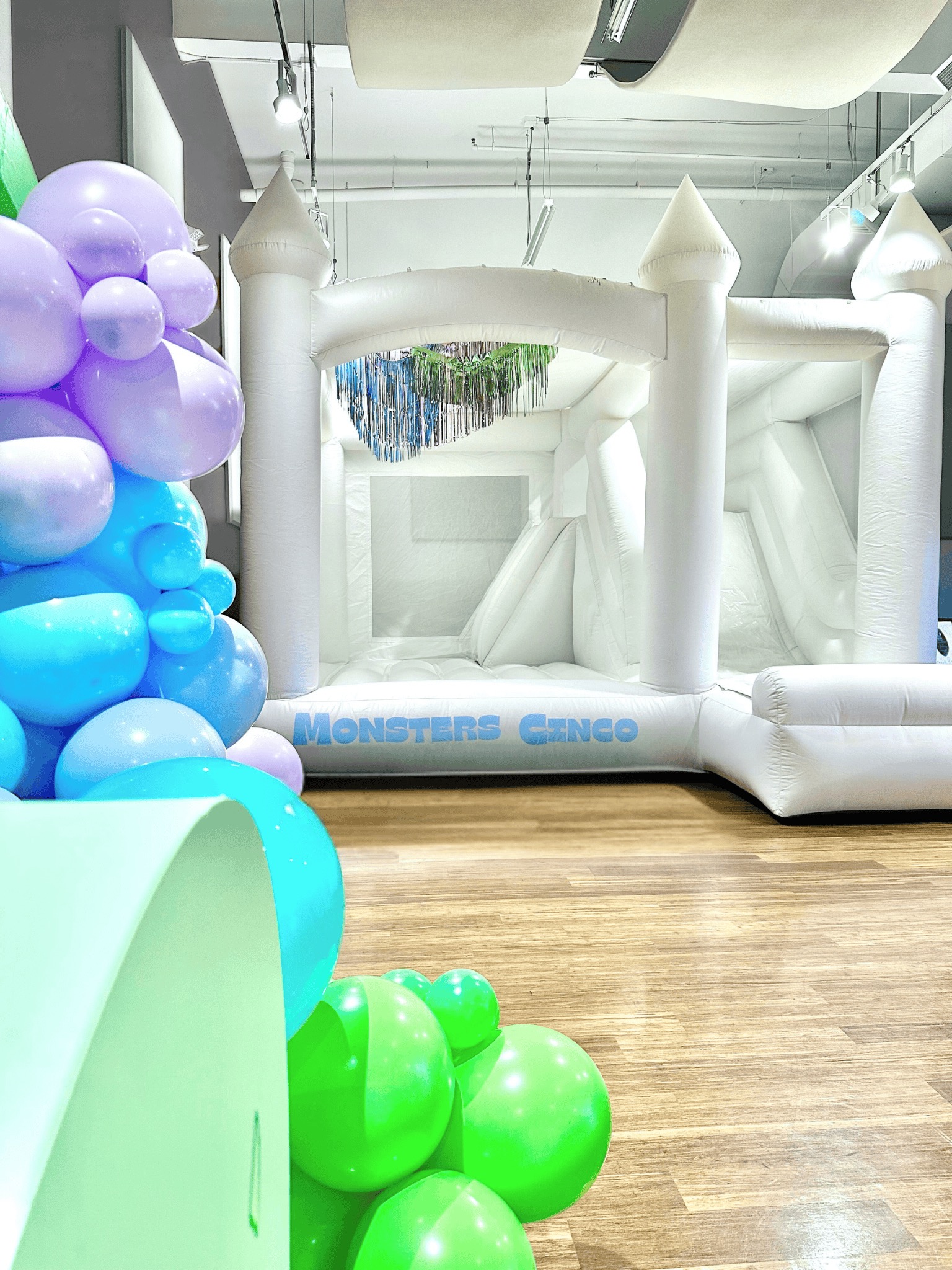 Fringe Styling white bounce house with mint, powder blue, and lavender balloon garland for a fifth birthday in Monroe, WA