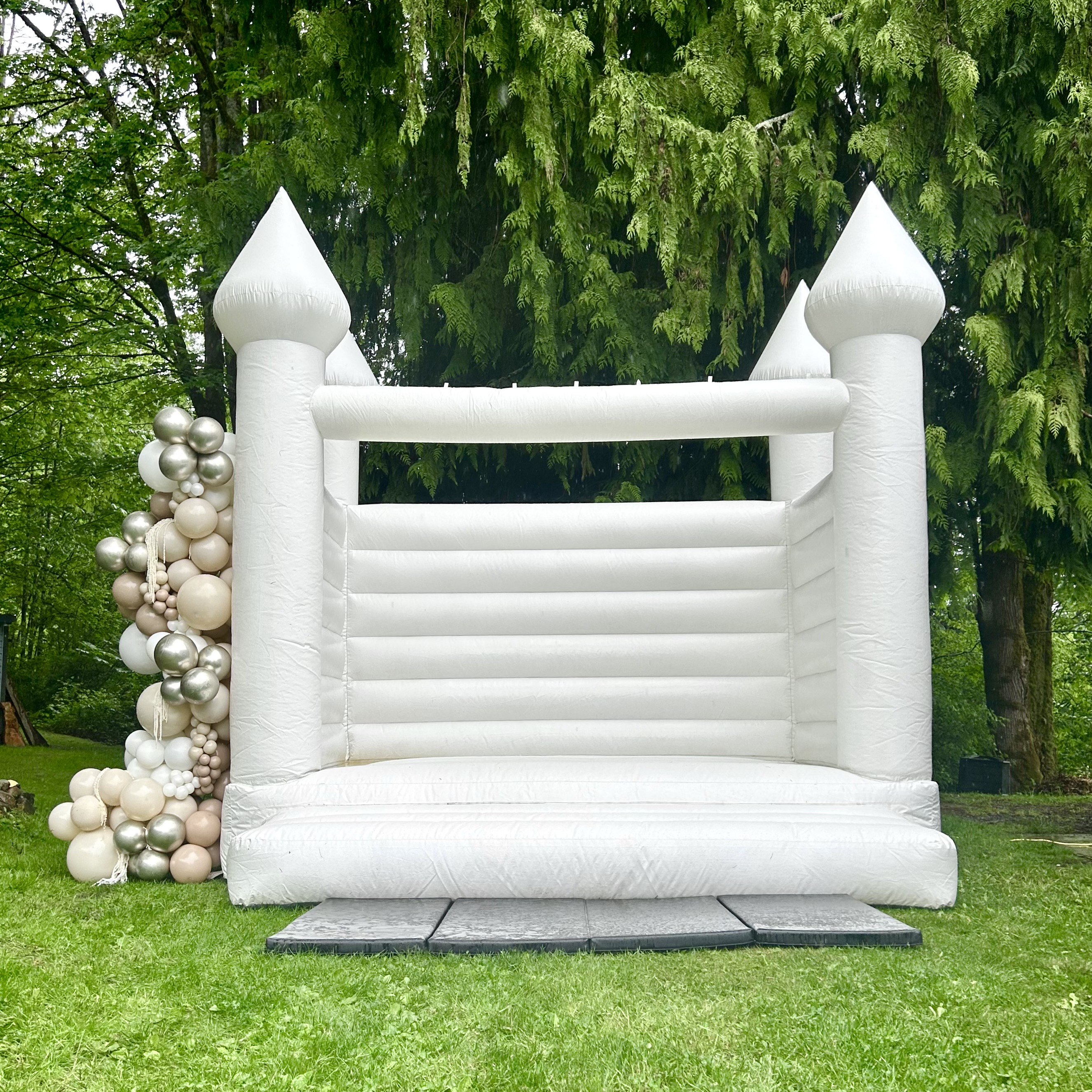 Magnolia white bounce house with white, sand, and chrome balloon garland for a Wedding in Seattle, WA