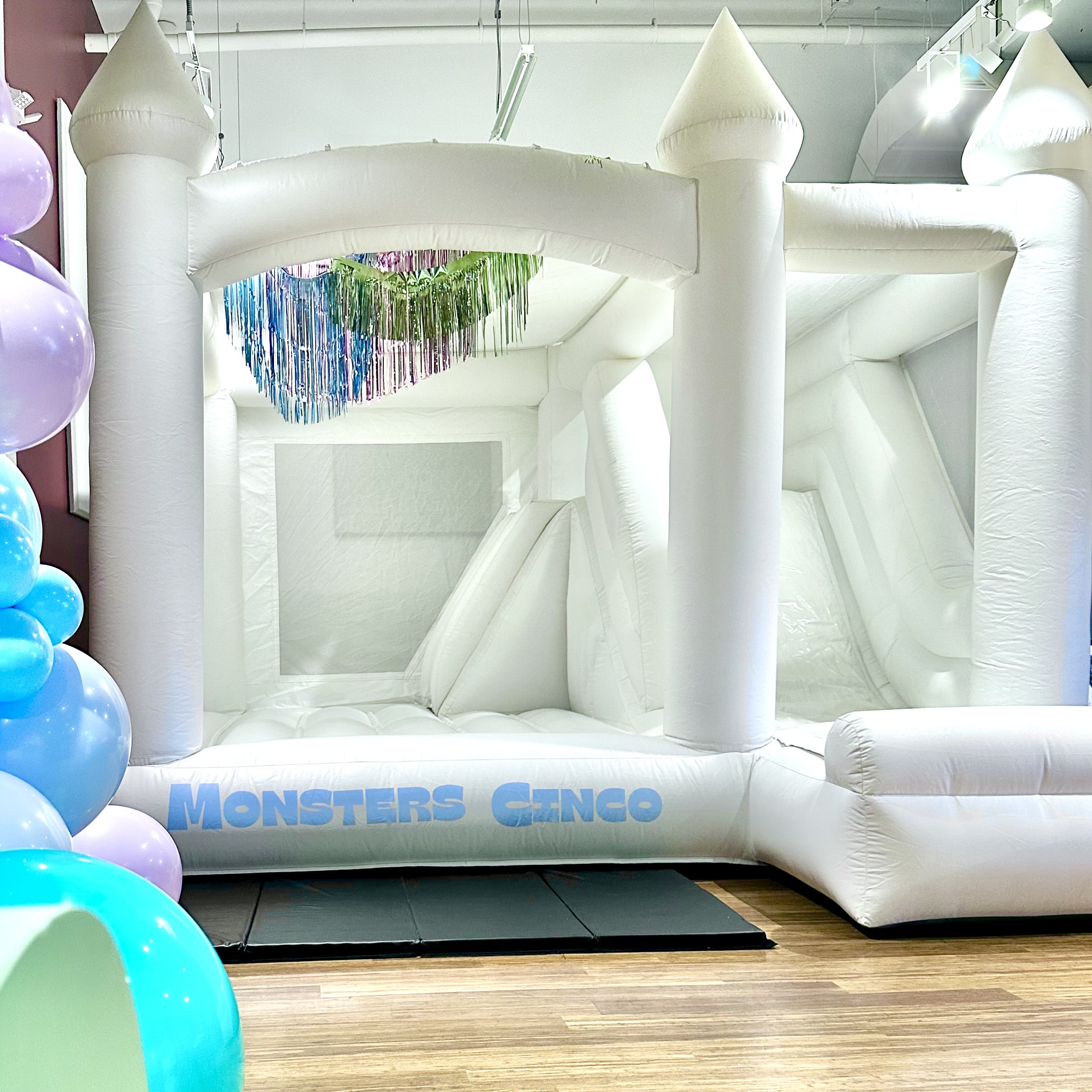 Ranier white bounce house with balloon garland for a birthday at Northwest African American Museum in Seattle WA